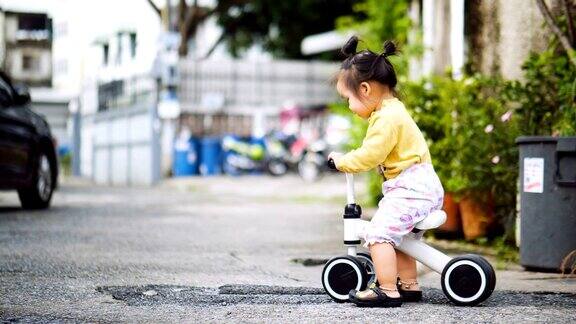 年轻快乐的亚洲小女孩骑着自行车