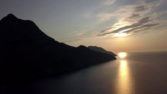 橙色的夕阳在海面上与船惊人的金色反射的太阳在平静的波浪