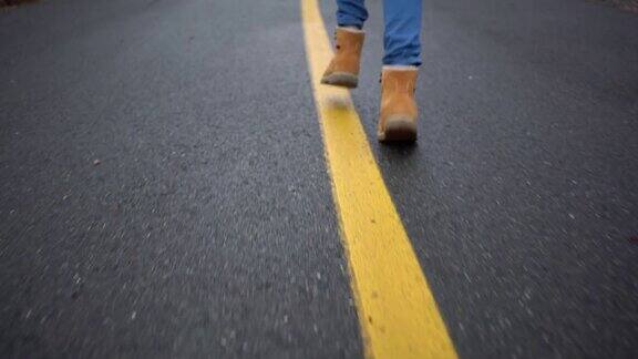 少年穿着黄色的靴子走在路上