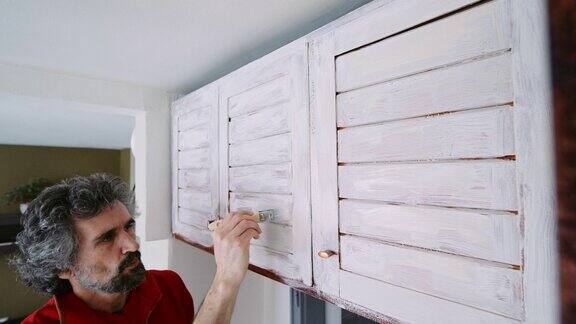 DIY男人油漆厨房木制家具白色关闭家庭改善和修理