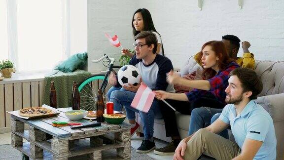 快乐的朋友和奥地利国旗一起在家里看电视体育冠军并为赢得最喜欢的球队而高兴