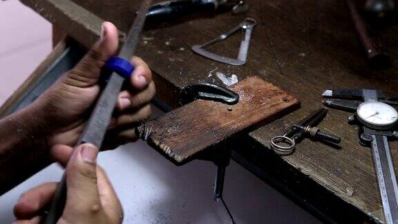珠宝工匠打磨戒指的蜡模用粗平锉