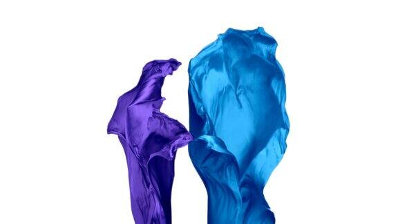 蓝色和紫色的织物在白色的背景上流动慢镜头