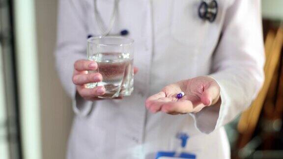 医生用手递给我一颗蓝白色的药丸和一杯水