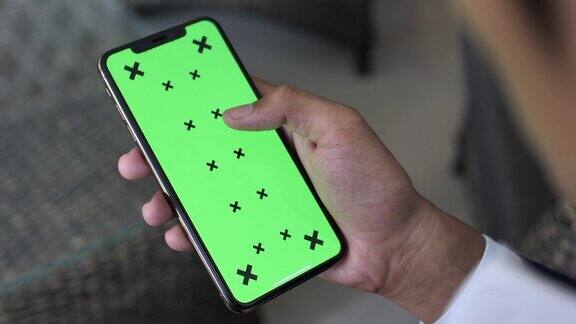 男人的手使用绿色模拟屏幕智能手机