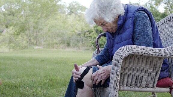 简介拍摄的老年白人妇女的膝盖关节炎疼痛正午户外在夏天