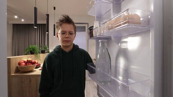 十几岁的男孩从冰箱里拿酸奶