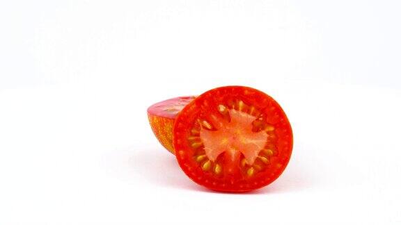 两半颗红球条纹番茄慢慢旋转在转盘上孤立的白色背景特写镜头宏