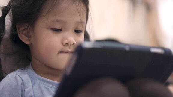亚洲小女孩看和玩数字平板电脑
