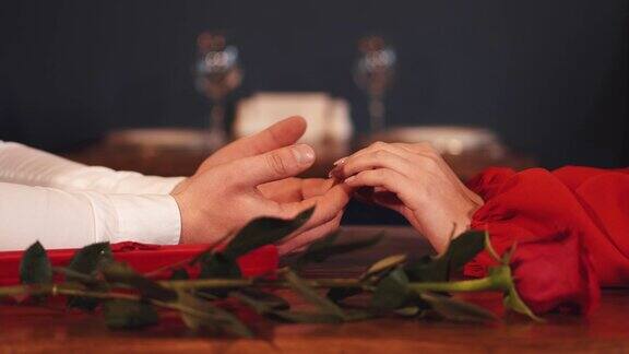 男性和女性的手握在桌子上的裁剪视图