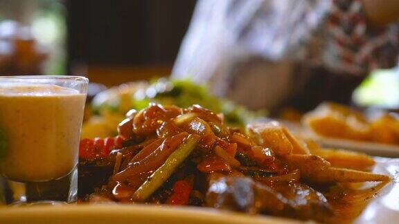 新鲜烹饪的牛排在桌子上与亚洲女人用餐在模糊的背景健康饮食与饮食观念