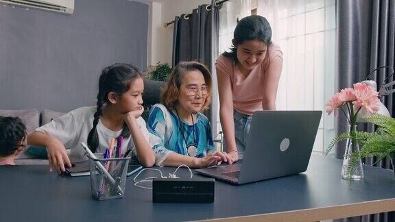奶奶坐在电脑上学习如何使用互联网教孙子