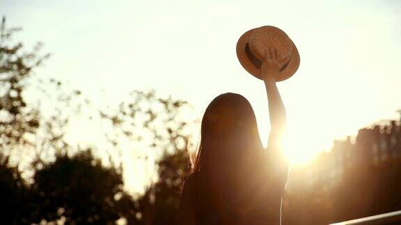 日落时分女人拿着帽子