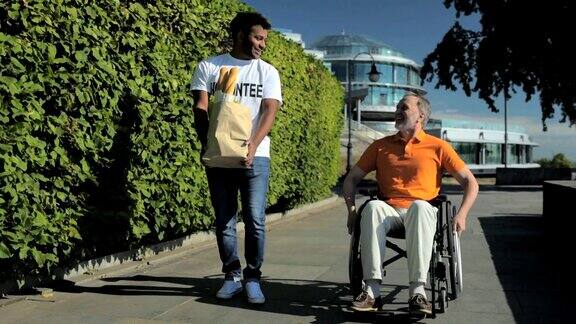 积极的志愿者帮助坐轮椅的人搬运产品