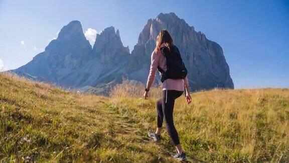 女性徒步旅行者在群山中爬山周围是令人难以置信的风景