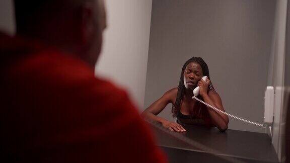 非洲妇女与她的丈夫在探视室使用电话交谈