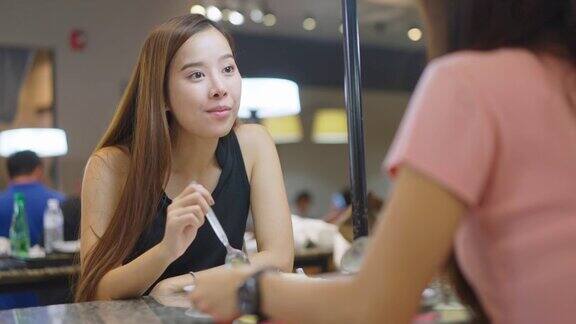 亚洲年轻美丽的女人与朋友在餐厅午餐女孩们在一起谈笑风生享受美食笑口常开