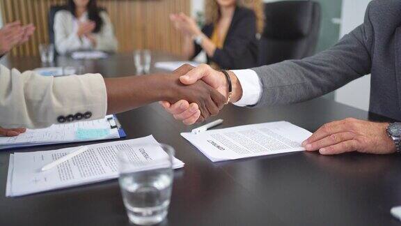 商务人士在成功会面并达成协议后隔着桌子握手