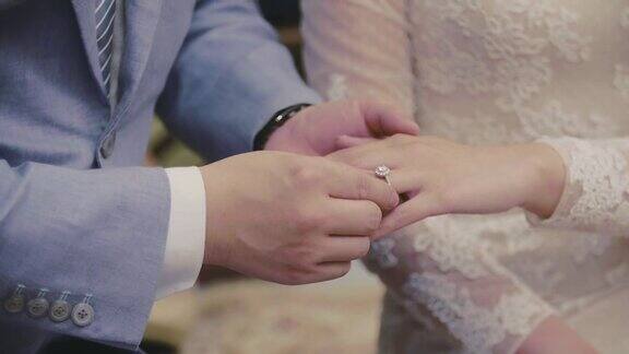 新郎在婚礼上给新娘戴上戒指