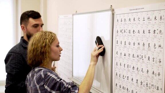 一个年轻的男人和一个女人在教室里一起学习象形文字