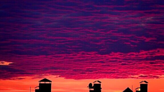 美丽的粉红色晚霞飘过小镇的屋顶全高清晚上时间流逝
