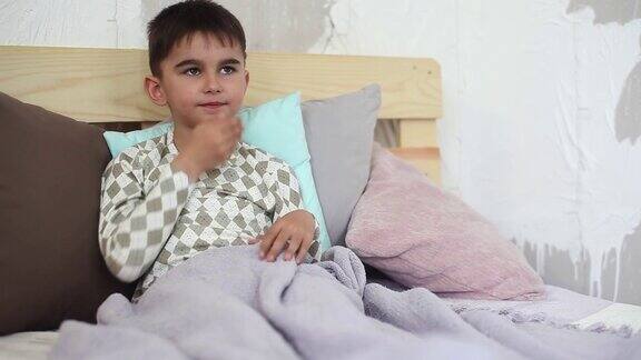 那个小男孩病了躺在床上咳嗽