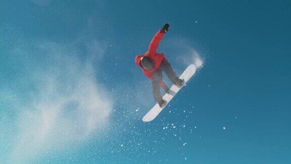 慢镜头特写:滑雪板跳跃和喷洒雪在冬天的天空