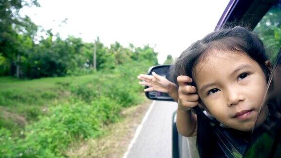 两个小女孩在乡下旅行时一起在车窗上玩