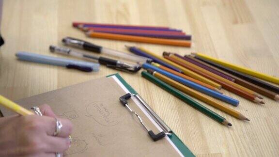 这是艺术家的手的特写图像工作场所有许多彩色铅笔