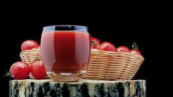 将番茄汁倒入黑色背景的木板上的玻璃杯中稻草篮里的新鲜西红柿番茄制品