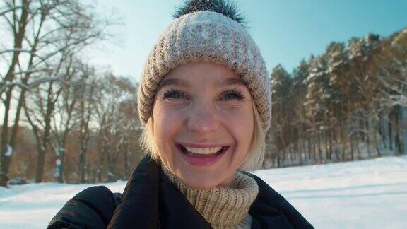 年轻美丽的女人在一个寒假里拍一张被雪景包围的自拍
