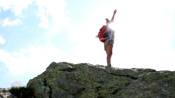 年轻女子徒步攀登山峰-成功和自由