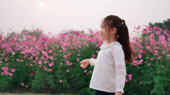 可爱的小女孩在美丽的花园里玩玩具飞机