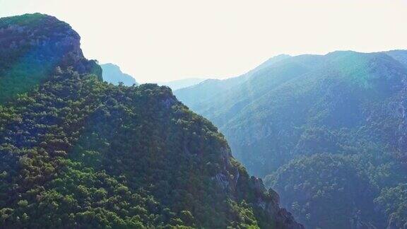 无人机在日落的背景下飞过一座山