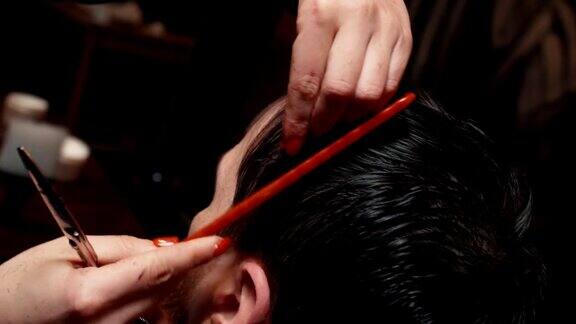 一个留着胡子的年轻人在理发店剪头发特写