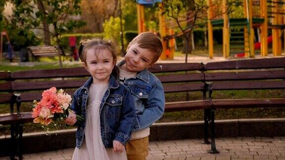 一对小情侣捧着一束花相爱了一个男孩拥抱着一个小女孩