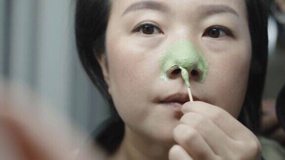 一名年轻女子正在切除鼻子上的毛孔