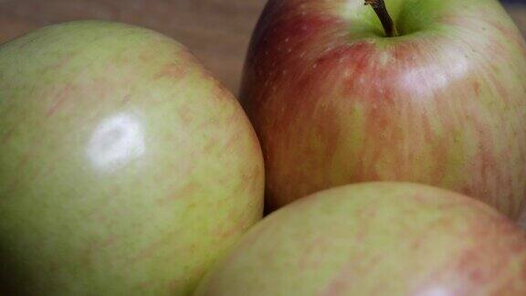 三个漂亮的大苹果放在旋转的表面上宏观的视频水果特写