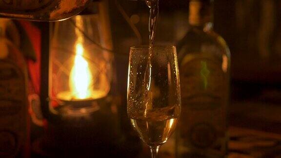 特写一个人倒龙舌兰酒在一个香槟长笛点燃灯笼