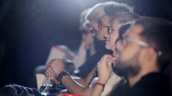 一群人戴着3D眼镜在电影院看电影