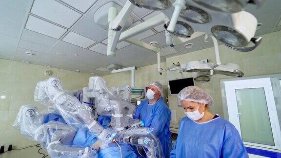 配备医疗设备的现代化手术室手术机器人的操作过程医生和护士控制机器人手术创新医学概念