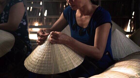 4k镜头低光场景特写的越南工匠制作传统的越南帽子在老传统的房子在ApThoiPhuoc村Cantho省越南传统艺术家