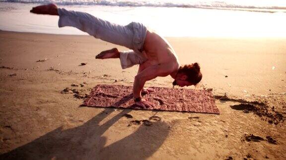 日落时分一个年轻人在海滩上做瑜伽