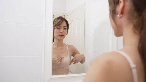 乳腺癌世界癌症日年轻的亚洲妇女检查触诊乳房肿块或癌症