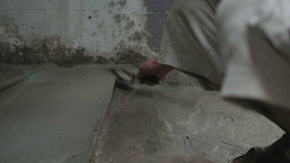 男人的手正在用泥铲抹地板建筑工人在家