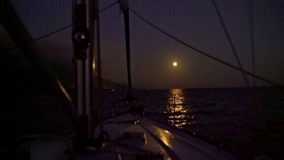 4K帆船向着满月驶去在宁静的夜晚照耀着大海