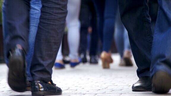 人群无名的人走在街上人群的脚
