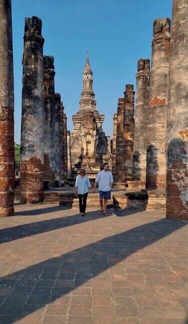 一对男女参观泰国素可泰老城的马哈塔寺古城与文化