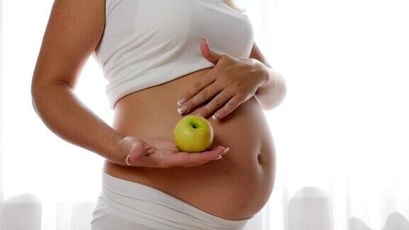 怀孕期间的营养和饮食孕妇在肚子里保持绿色苹果
