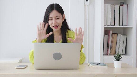 年轻的亚洲商务女性使用笔记本电脑进行在线视频会议与社交距离商务女性工作与视频电话新常态沟通概念慢动作